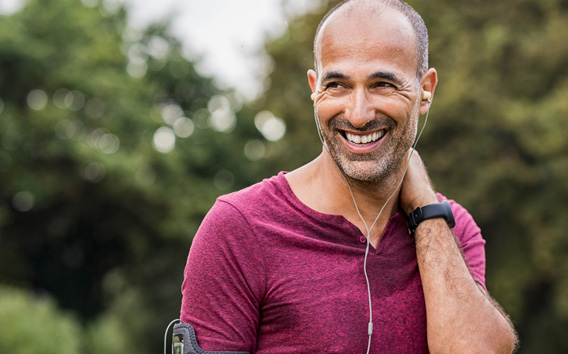 Mann hört Musik und ruht sich nach dem Joggen aus